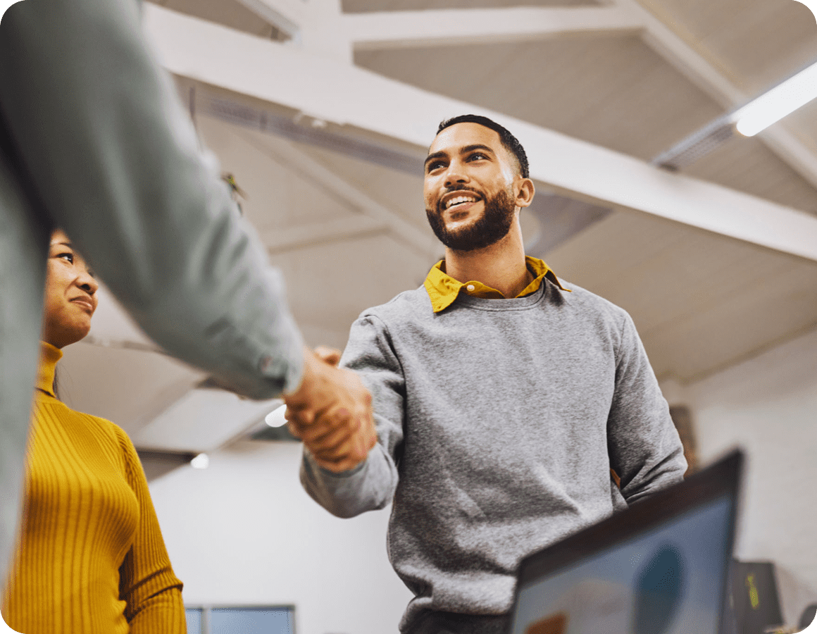 People shaking hands in an office setting.