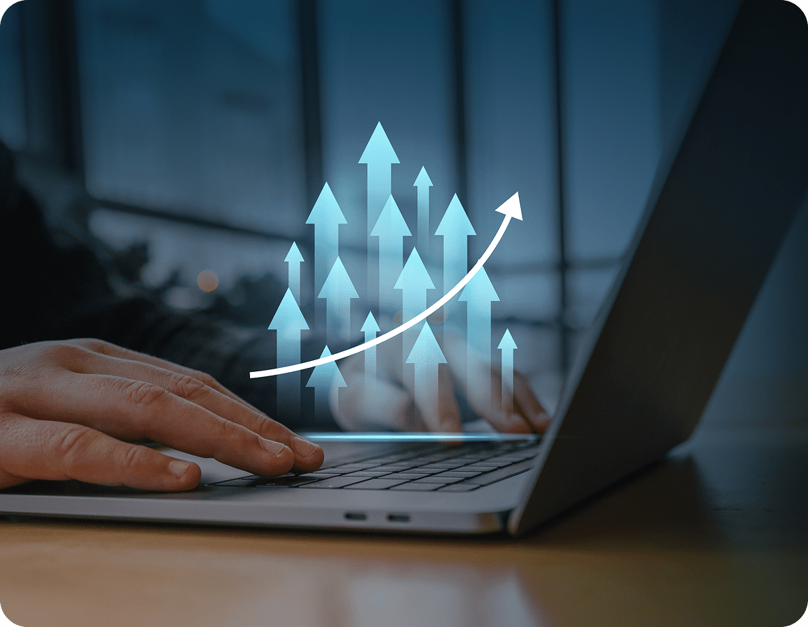 Hands typing on laptop with growth arrows.