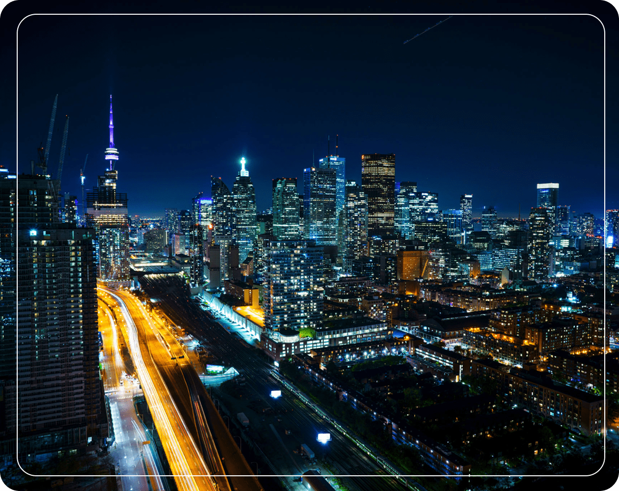 City skyline at night with illuminated buildings.